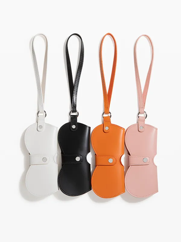 Quatre étuis à lunettes en cuir de couleurs différentes sur fond blanc